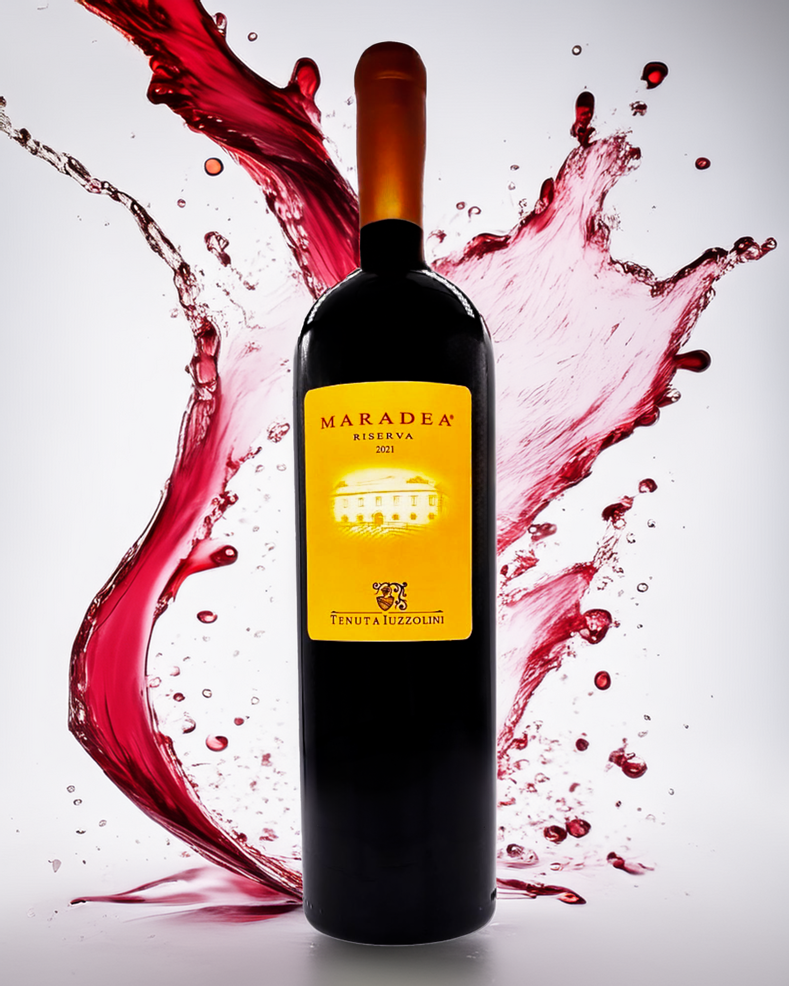 Flasche Maradea Rotwein von Tenuta Iuzzolini mit frischen Trauben und dynamischem Weinsplash – idealer italienischer Rotwein aus Kalabrien.
