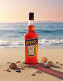 Aperol Flasche am Strand bei Sonnenuntergang mit Muscheln – italienischer Aperitif für Sommer und Aperol Spritz