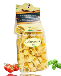 Kalabrische Pasta Calamarata 500g von Colacchio – italienische Hartweizennudeln in transparenter Verpackung mit Tomaten und Basilikum auf weißem Hintergrund