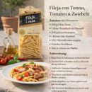 Italienische Fileja Pasta mit Thunfisch, Tomaten und Basilikum auf Teller serviert, Colacchio Pasta Packung im Hintergrund, mediterrane Rezeptidee
