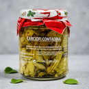 Zarte ganze Artischockenherzen in Kräuteröl, angerichtet in einer Schüssel mit Oliven – servierfertig auf einem rustikalen Holztisch mit italienischem Flair.