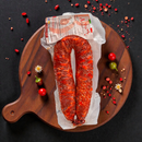 Nduja di Spilinga Bellantone auf Holzbrett mit roten Chilischoten – scharfe italienische Wurstspezialität aus Kalabrien, handwerklich hergestellt