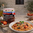 Spaghetti mit Pesto Rosso, Basilikum und Oliven – italienisches Pasta Gericht mit Pesto Rosso Glas, mediterrane Spezialität