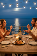 Italianisches Abendessen am Meer mit Wein, Pasta und Freunden – mediterrane Atmosphäre mit Weißwein und italienischer Küche