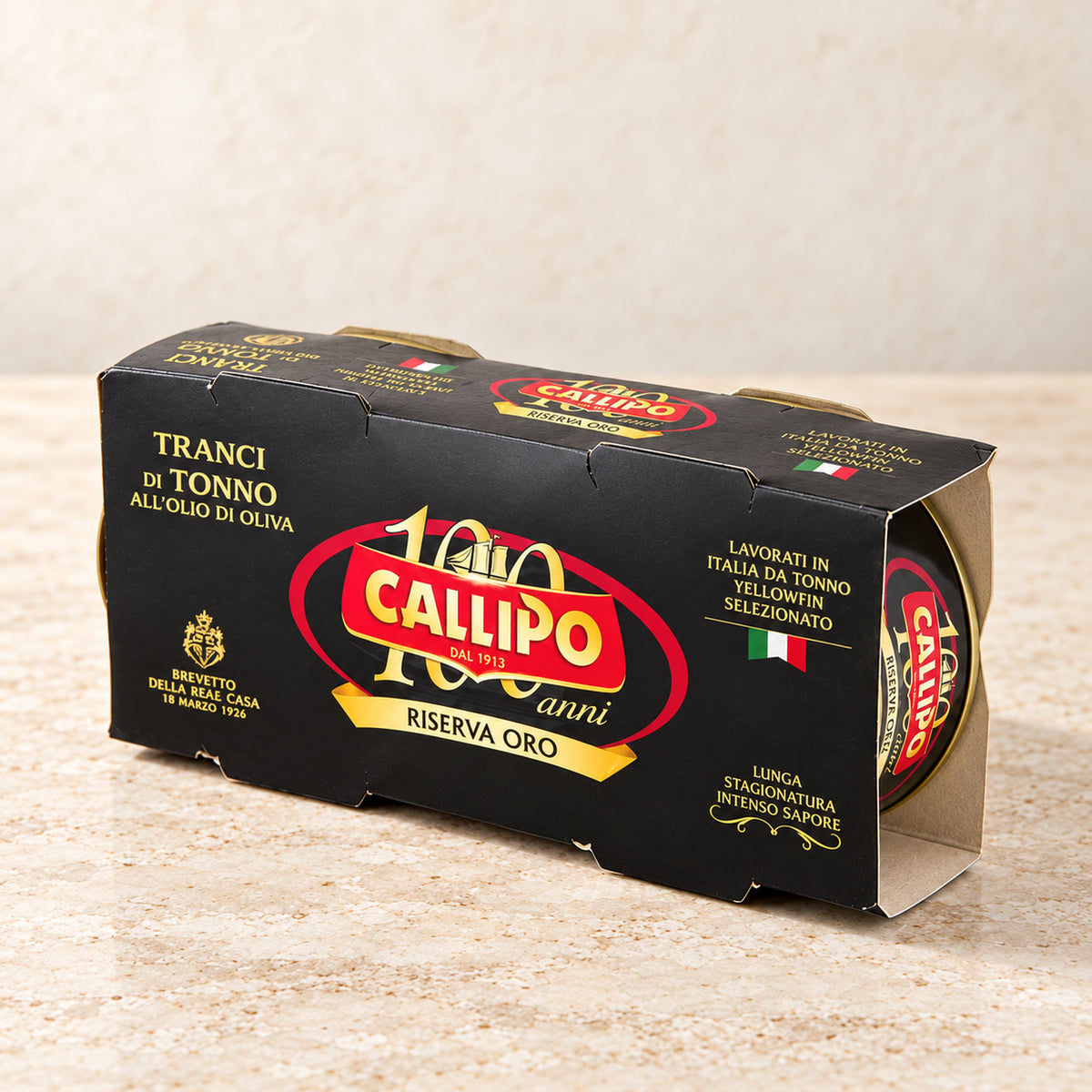 Callipo Riserva Oro Thunfisch in Olivenöl im schwarzen 2er-Pack auf cremefarbenem Travertin