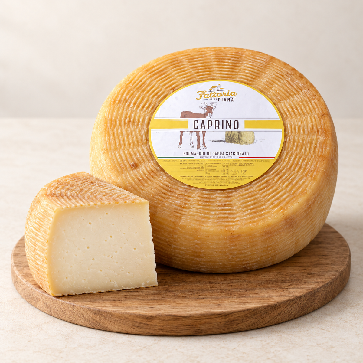 Caprino della Piana mit ganzem Käse und einem angeschnittenen Stück auf Holz; verkauft wird eine 300-g-Portion.