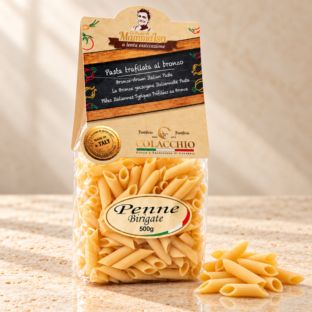 Penne Birigate Colacchio Mamma Isa – Bronzegezogene Pasta, 500 g – helle Produktaufnahme auf beigem Stein mit leicht seitlicher Perspektive