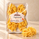 Tagliatelle all’Uovo Colacchio Mamma Isa – Eierbandnudeln, 250 g – helle Produktaufnahme auf beigem Stein mit leicht seitlicher Perspektive