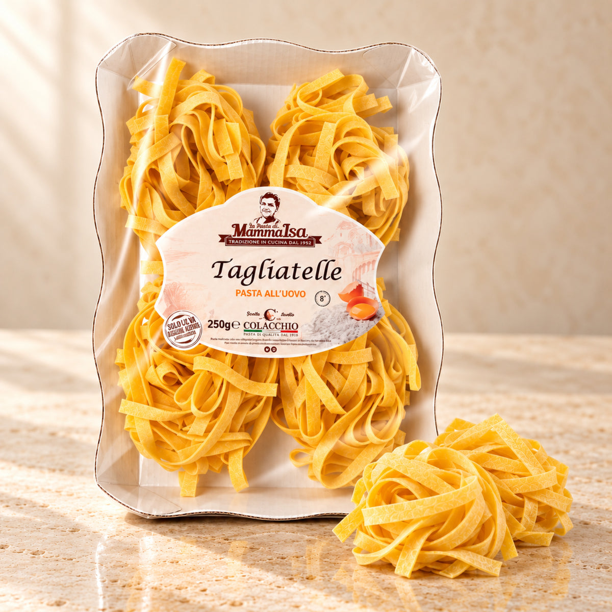 Tagliatelle all’Uovo Colacchio Mamma Isa – Eierbandnudeln, 250 g – helle Produktaufnahme auf beigem Stein mit leicht seitlicher Perspektive