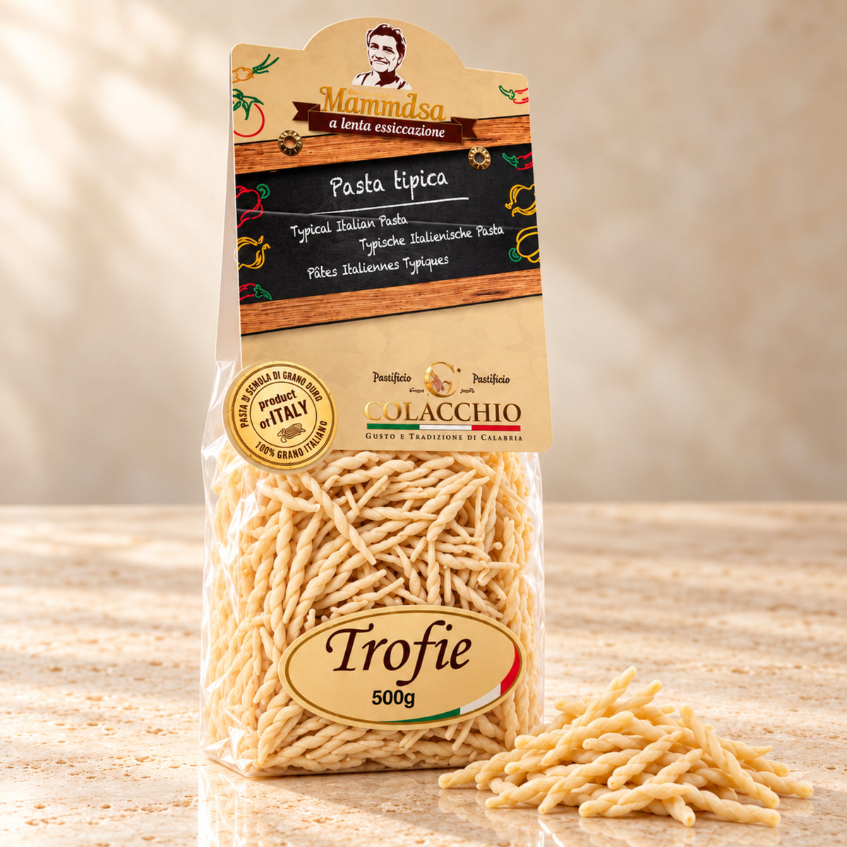 Trofie Colacchio Mamma Isa – Traditionelle Pasta aus Kalabrien, 500 g – helle Produktaufnahme auf beigem Stein mit leicht seitlicher Perspektive