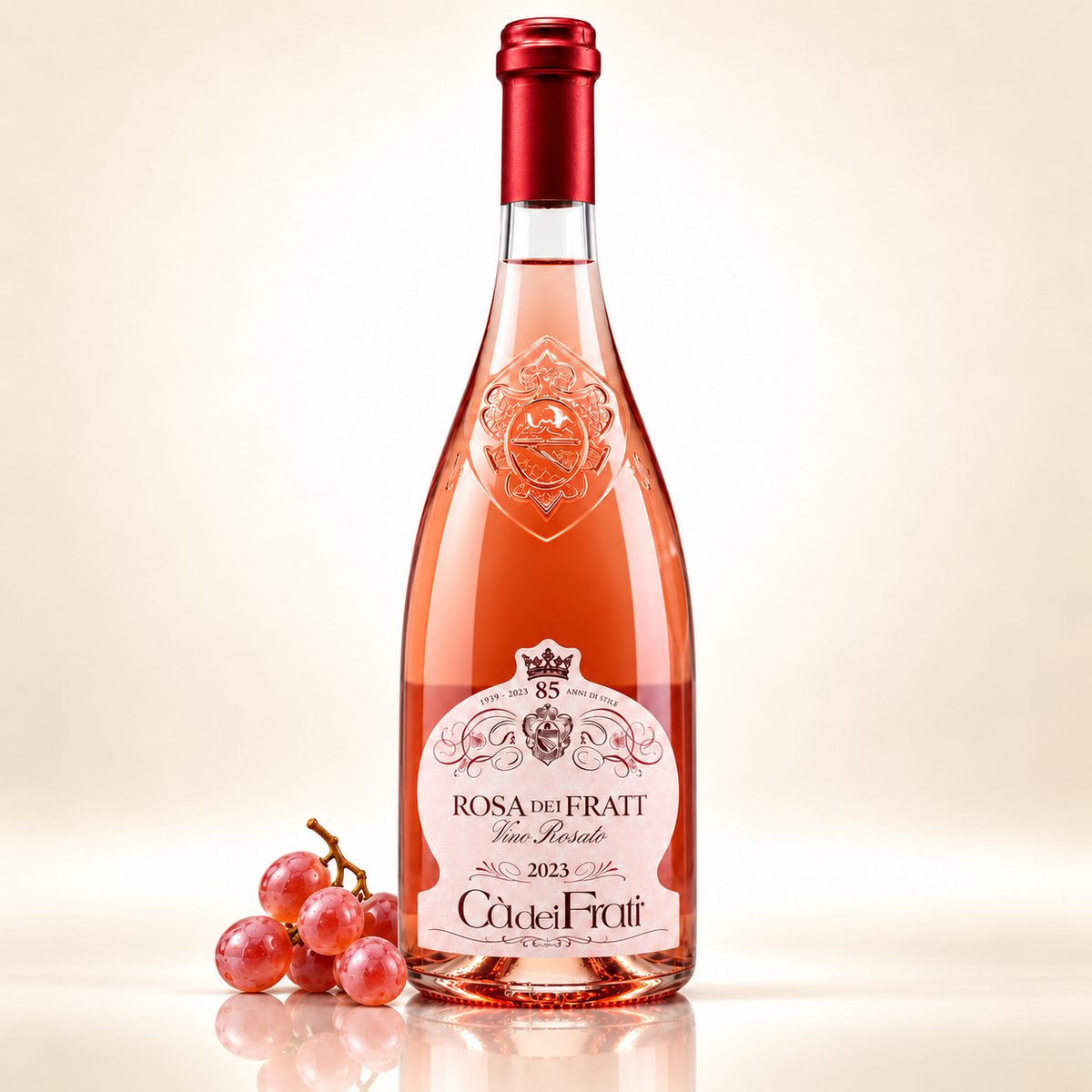 Italienischer Roséwein kaufen – Rosa Cà dei Frati 2023 – 750 ml – mit rosafarbenen Trauben auf cremefarbenem Hintergrund mit Spiegelung