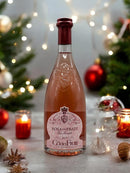 Rosa dei Frati Vino Rosato Flasche von Ca' dei Frati, weihnachtlich dekoriert, mit Kerzen und festlichem Hintergrund voller Lichter.