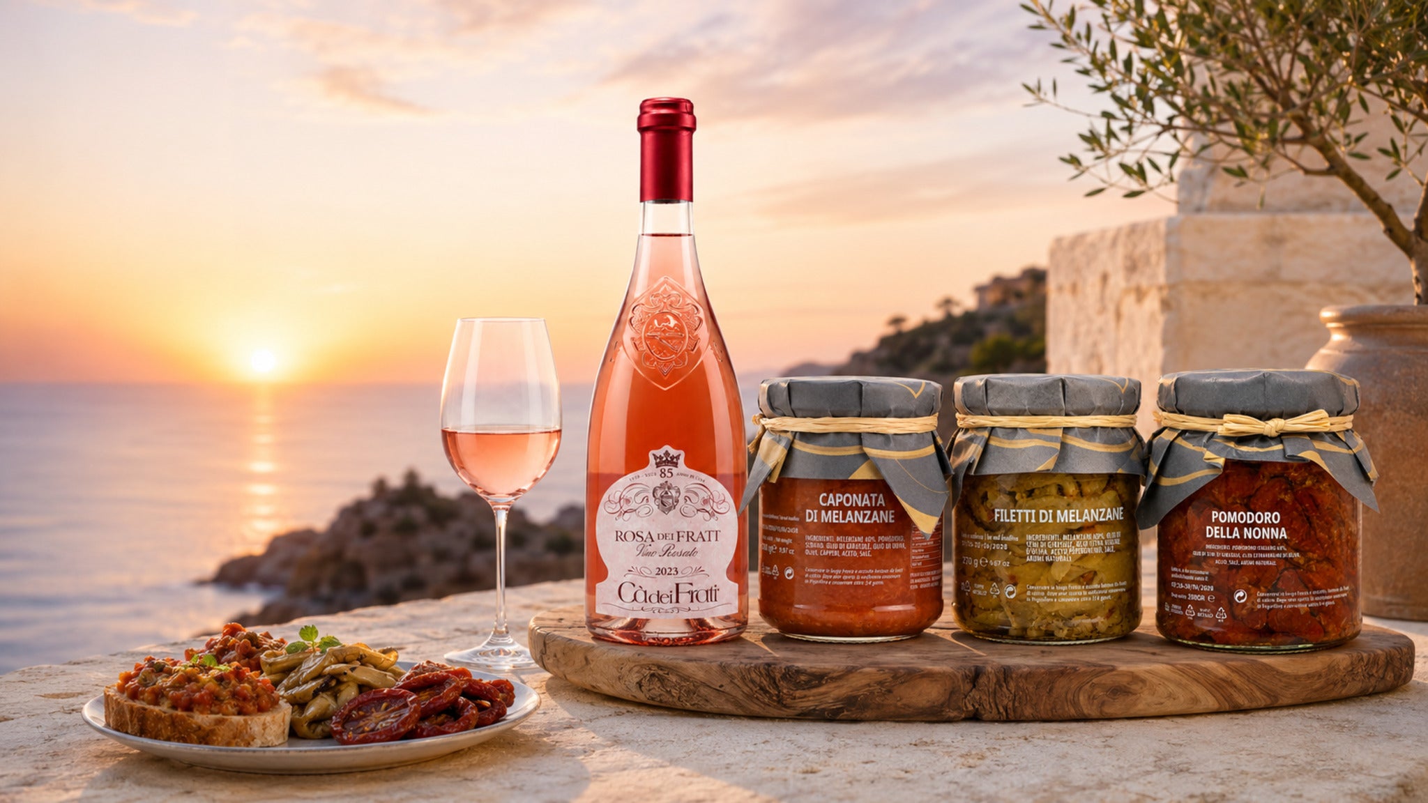 Sizilianischer Aperitivo bei Sonnenuntergang mit Roséwein, Caponata, Auberginen und getrockneten Tomaten