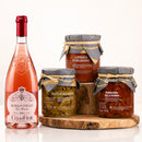 Sizilianisches Aperitivo Paket mit Rosa dei Frati Rosé, Caponata, Filetti di Melanzane und Pomodoro della Nonna auf Holz vor weißem Hintergrund