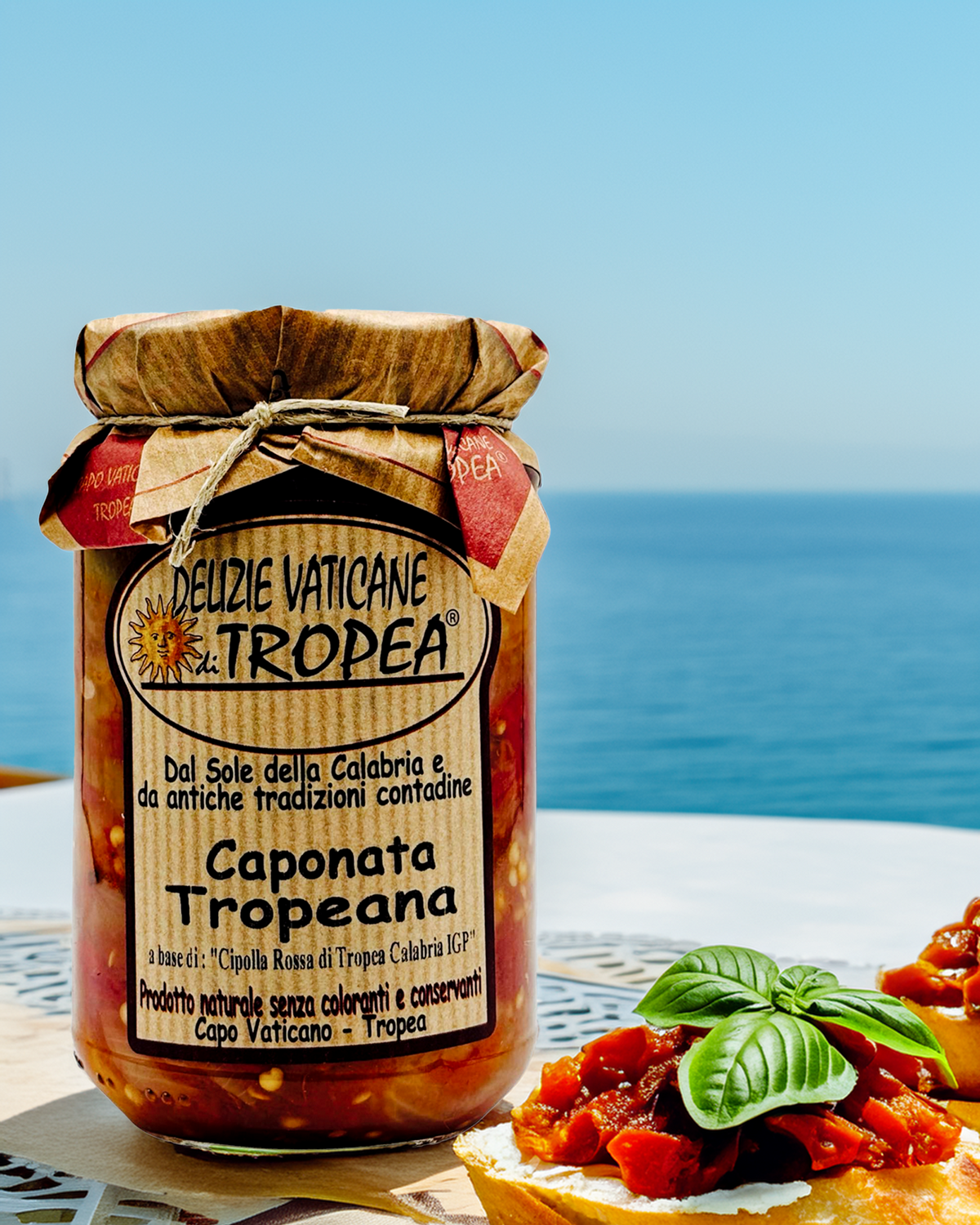 Caponata Tropeana im Glas – serviert mit Bruschetta und frischem Basilikum auf einem italienischen Tisch mit Meerblick, mediterrane Atmosphäre aus Kalabrien

